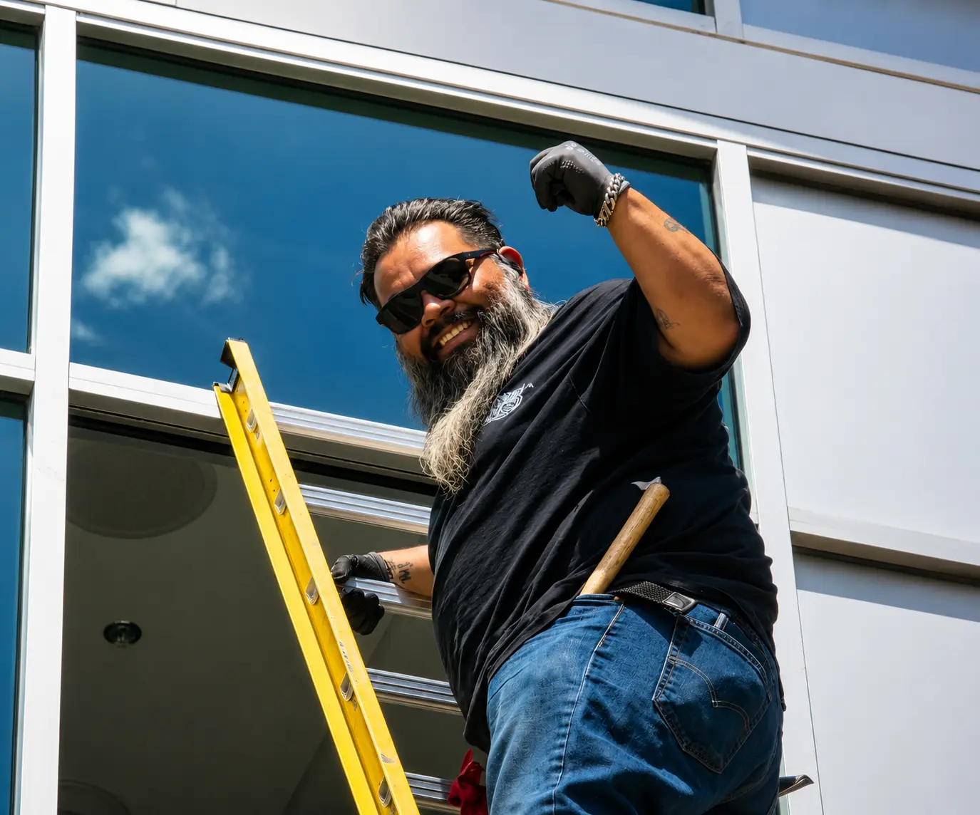 Mile High Glass team member working from a ladder on a commercial window